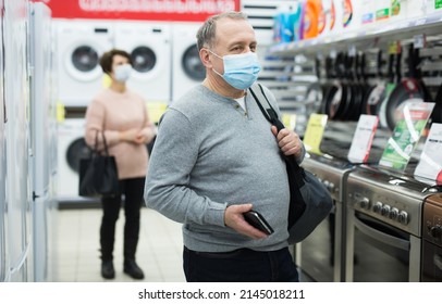 Portrait Of A Confident European Man In A Protective Mask Who Came Shopping At An Electronics And Home Appliance Store During ..the Pandemic