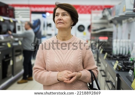 Portrait of a confident European woman who came in an electronics and household appliance shop for a purchase in the gas ..stoves department