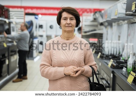 Portrait of a confident European woman who came in an electronics and household appliance shop for a purchase in the gas ..stoves department