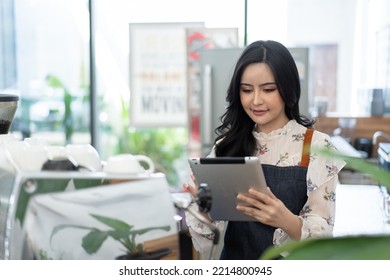 Portrait Of Confident Female Barista Standing Behind Counter. Woman Cafe Owner In Apron Looking At Camera And Smiling.