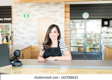 Portrait Of Confident Female Cashier At Checkout Counter In Supermarket