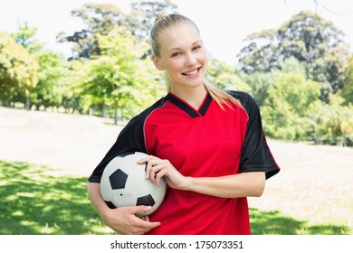 Portrait of confident female soccer player with ball at park - Powered by Shutterstock