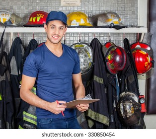 Portrait Of Confident Firefighter Holding Clipboard At Fire Station