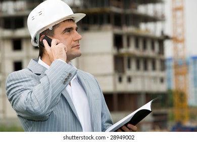 Portrait of confident foreman calling by the phone and holding document - Shutterstock ID 28949002