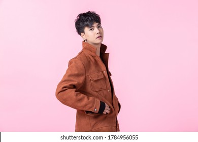 Portrait Of Confident Handsome Young Asian Man With Keeping Hands In Pockets Of Pocket The Side Eyes Looking At Camera In Isolated On Pink Blank Copy Space Studio Background.