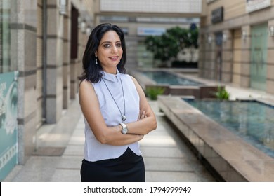 Portrait of confident Indian business woman in corporate building. Smiling female wearing smart formal attire.