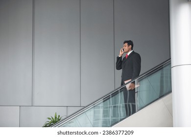 Portrait of a confident Indian businessman standing on an escalator in the city. - Powered by Shutterstock