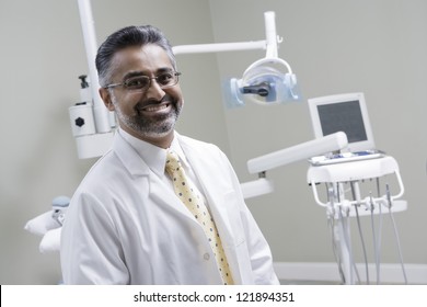 Portrait Of A Confident Indian Male Dentist In Clinic