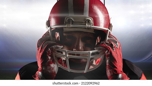 Portrait of confident male american footballer adjusting helmet at illuminated sports field. competitive sport, challenge and protection. - Powered by Shutterstock