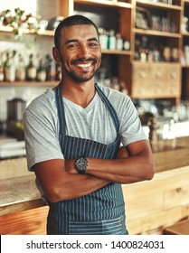 Portrait Of Confident Male Barista At Counter In Cafe