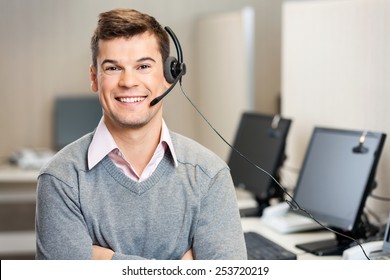 Portrait Of Confident Male Customer Service Representative With Headset In Call Center