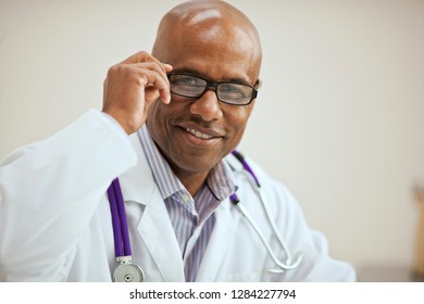 Portrait of a confident male doctor adjusting his glasses. - Powered by Shutterstock