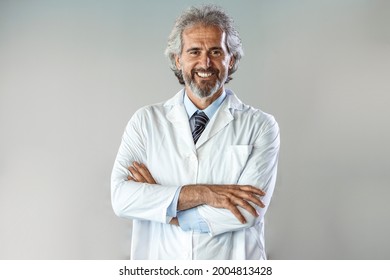 Portrait Of Confident Male Doctor Standing Arms Crossed In Hospital. Doctor Senior Man, Medical Professional With Crossed Arms Confident And Happy With A Big Natural Smile Laughing At Hospital