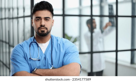 Portrait of confident male doctor standing in hospital lobby - Powered by Shutterstock