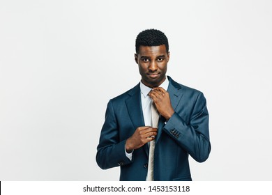 Portrait of a confident man in business suit, fixing his tie