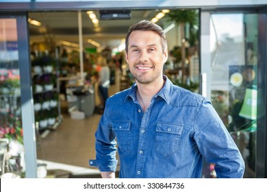 Portrait Of Confident Man Standing Outside Flower Shop