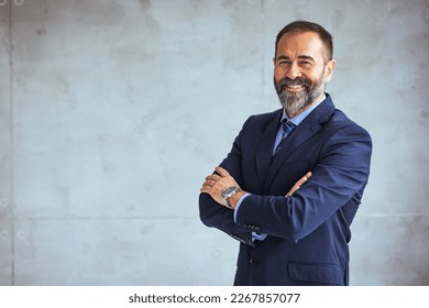 Portrait of a confident mature businessman working in a modern office. Mature cheerful executive businessman at workspace office. Portrait of smiling ceo at modern office workplace in suit  - Powered by Shutterstock