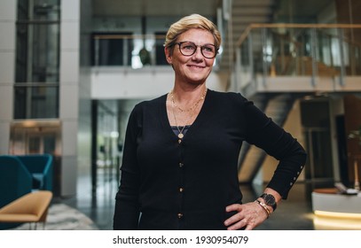 Portrait of confident mature businesswoman standing in office building. Caucasian female entrepreneur looking away with her hand on hip. - Shutterstock ID 1930954079