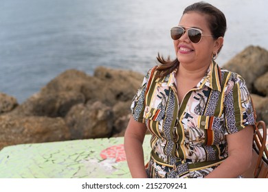 Portrait Of Confident Mature Woman Sitting On A Park Bench