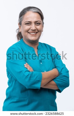 Portrait of confident mature woman wearing formalwear with arms crossed standing against white background