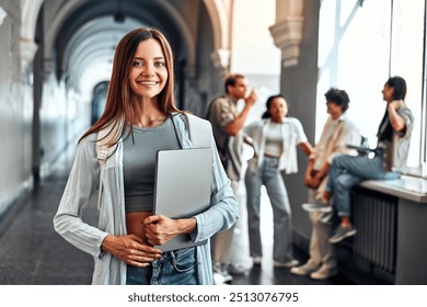 Portrait of confident motivated modern smiling female college student holding laptop and smiling. Concept of education and student life. - Powered by Shutterstock