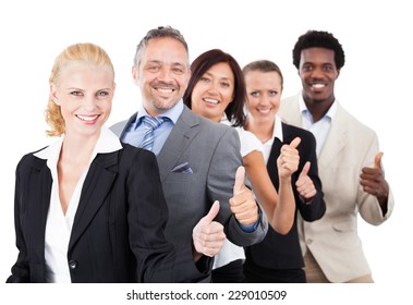 Portrait of confident multiethnic business people gesturing thumbsup over white background