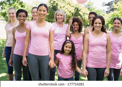 Portrait of confident multiethnic women and girl supporting breast cancer awareness at park