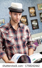 Portrait Of A Confident Music Store Owner With Book