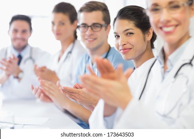 Portrait Of Confident Nurse And Doctors Applauding In Hospital