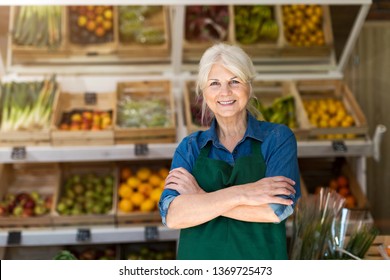 Portrait Of Confident Owner With Arms Crossed Standing In Small Grocery Store