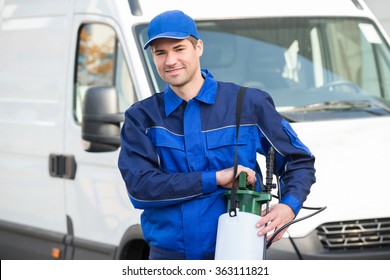 Portrait Of Confident Pest Control Worker With Pesticide Against Truck