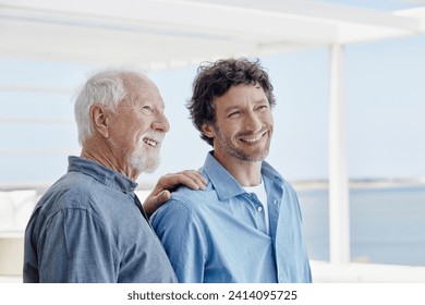 Portrait of confident senior man with adult son at a beach house - Powered by Shutterstock