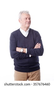 Portrait Of Confident Senior Professional Man Standing Against White Background. Arms Crossed Businessman Wearing Casual Clothing And Looking Away While Smiling. 