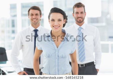 Portrait of a confident smiling business team standing in a bright office