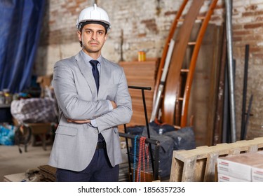 Portrait Of Confident And Strict Manager In Suit And Helmet At Construction Site