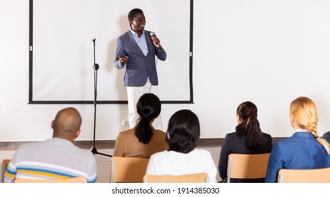 Portrait of confident successful man giving motivation training at conference hall
