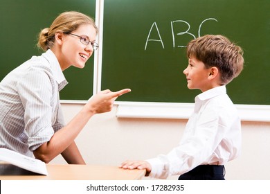 Portrait of confident teacher explaining grammar to schoolchild who looking at her attentively