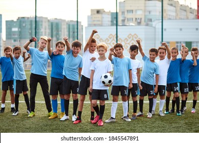 portrait of confident team of young football players posing at camera, athletic boys in uniform going to play football or soccer. in stadium - Powered by Shutterstock