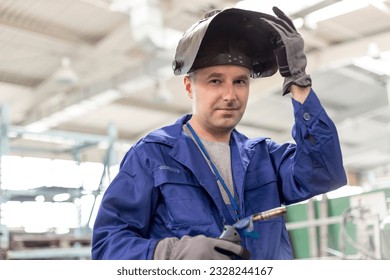 Portrait confident welder with welding torch in factory - Powered by Shutterstock