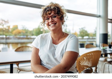 Portrait of a confident woman with eyeglasses in office. Smiling businesswoman looking at camera. - Powered by Shutterstock