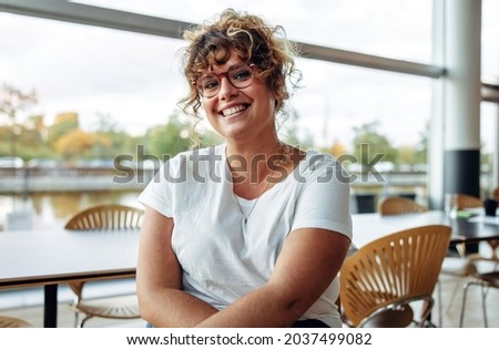 Portrait of a confident woman with eyeglasses in office. Smiling businesswoman looking at camera.