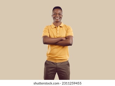 Portrait of confident young African American man isolated on brown studio background show leadership and power qualities. Smiling biracial male employee or worker pose with arms crossed. - Powered by Shutterstock