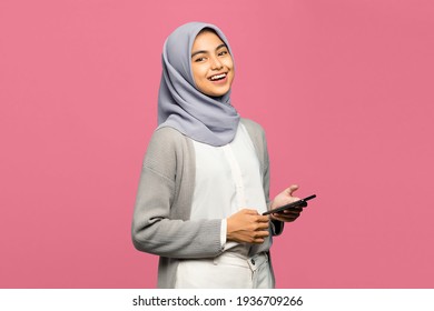 Portrait of confident young Asian woman holding mobile phone with smiling face - Shutterstock ID 1936709266