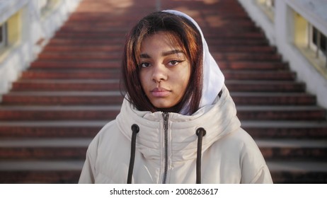 Portrait of confident young black woman looking serious at camera. Independent african american female on the city background.