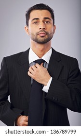 Portrait of a confident young businessman fixing his necktie