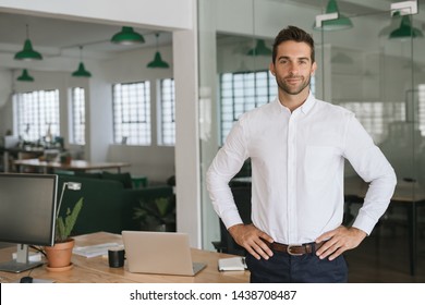 Portrait Of A Confident Young Businessman Standing Alone In A Large Modern Office With His Hands On His Hips