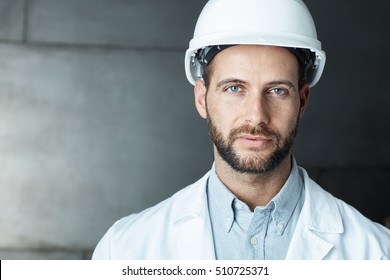 Portrait Of Confident Young Engineer Wearing Protective Hardhat.