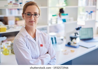 Portrait of a confident young female technician standing with her arms crossed in a modern lab - Powered by Shutterstock