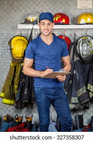 Portrait Of Confident Young Firefighter Holding Clipboard At Fire Station