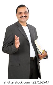 Portrait Of A Confident Young Indian Business Man Standing With Books